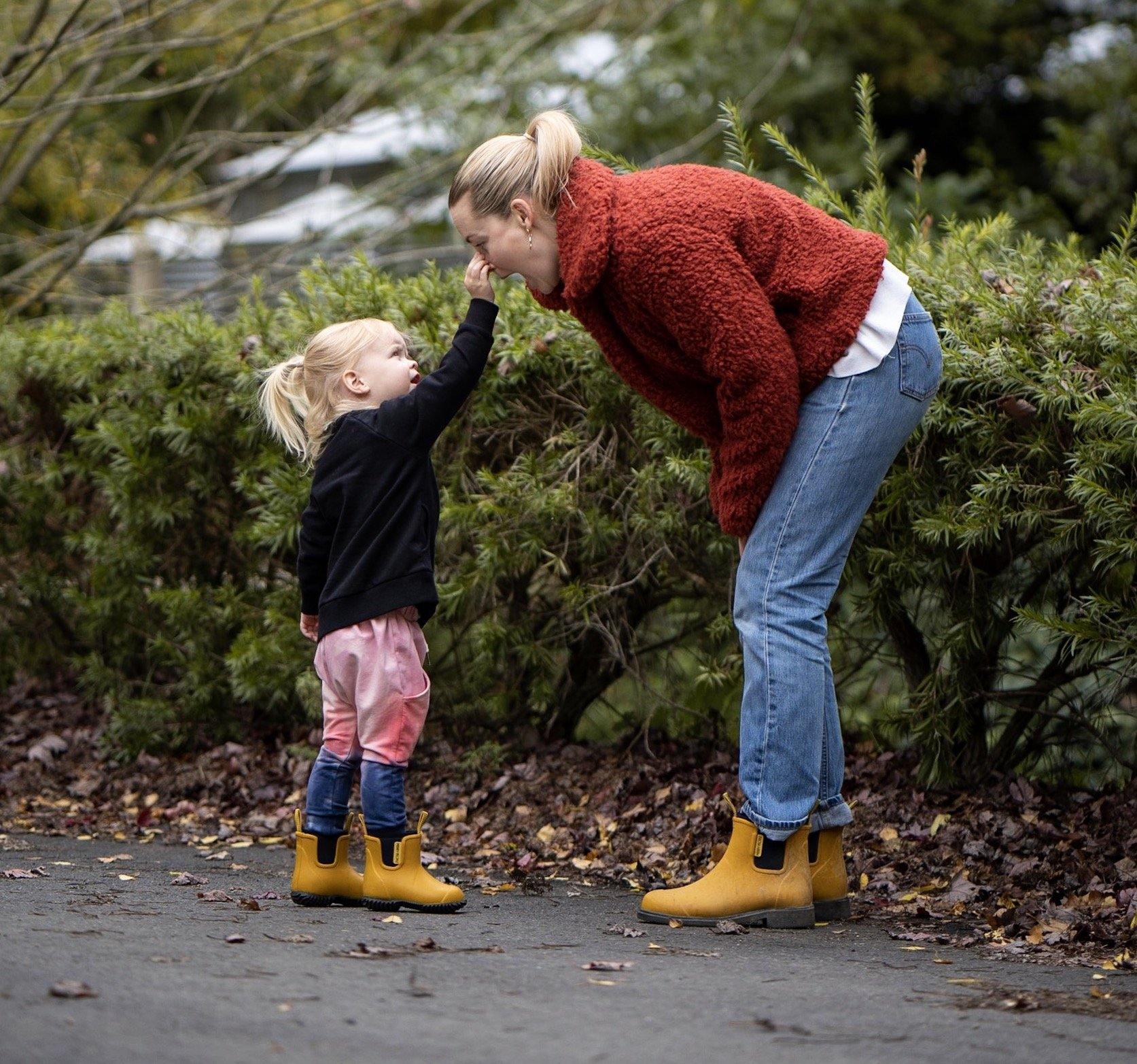 mother and daughter walking, wearing yellow rain boots